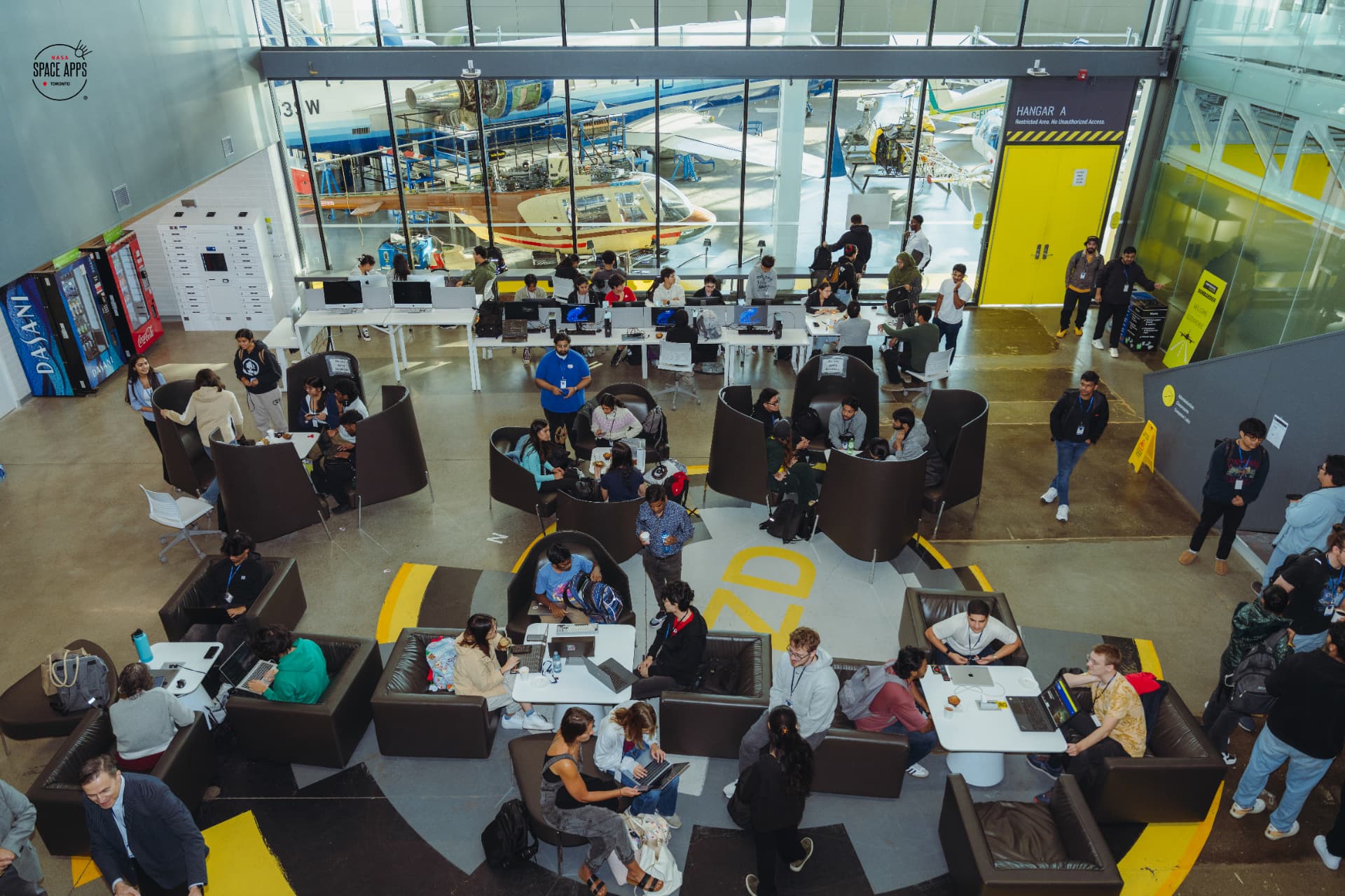 NASA Space Apps Toronto 2025 participants collaborating in the aerospace hangar